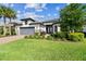 A beautiful property with lush landscaping, a well-maintained lawn, and blue skies overhead at 29356 Ginnetto Dr, Wesley Chapel, FL 33543