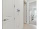 Bright hallway showcasing white doors and trim, a smart home control panel, and access to bedroom at 29356 Ginnetto Dr, Wesley Chapel, FL 33543
