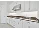 White kitchen cabinets, granite countertops, and stainless steel vent hood at 29356 Ginnetto Dr, Wesley Chapel, FL 33543