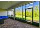 Screened-in lanai with brick flooring and a comfortable blue seating area overlooking the backyard at 29356 Ginnetto Dr, Wesley Chapel, FL 33543