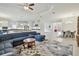 Open-concept living space featuring a kitchen with white cabinets, a dining area, and a plush blue sectional sofa at 29356 Ginnetto Dr, Wesley Chapel, FL 33543