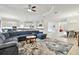 Open-concept living room with an oversized couch, tile flooring, and seamless flow to the kitchen and dining room at 29356 Ginnetto Dr, Wesley Chapel, FL 33543