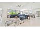 Open-concept living room with an oversized couch, tile flooring, a ceiling fan and seamless flow to the kitchen at 29356 Ginnetto Dr, Wesley Chapel, FL 33543