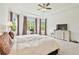Spacious main bedroom with white walls, tray ceiling, ceiling fan, plush carpet, and large windows offering natural light at 29356 Ginnetto Dr, Wesley Chapel, FL 33543