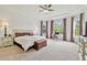 Spacious main bedroom with tray ceilings, large windows, neutral carpet, and access to ensuite bathroom at 29356 Ginnetto Dr, Wesley Chapel, FL 33543