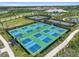 A vibrant aerial view of the community's pickleball courts surrounded by green space and landscaping at 29356 Ginnetto Dr, Wesley Chapel, FL 33543
