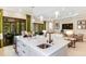 Kitchen island with white cabinets, sink, pendant lighting and seating with an open plan living area at 29936 Rusco Ct, Wesley Chapel, FL 33543