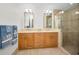 Bathroom featuring double sinks with marble countertops, vanity cabinets, and tiled glass door shower at 331 Cleveland St # 402, Clearwater, FL 33755