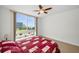 Bright bedroom with a large window offering water views, a ceiling fan, and neutral-toned carpet at 331 Cleveland St # 402, Clearwater, FL 33755