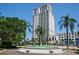 Elegant high-rise condo building with balconies and palm trees, fountain in front at 331 Cleveland St # 402, Clearwater, FL 33755