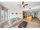 Light and airy living room adjacent to a modern kitchen with a tan sofa and access to a balcony at 331 Cleveland St # 402, Clearwater, FL 33755