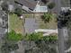 Bird's-eye view of the property showcasing the roof, lot lines, driveway and surrounding vegetation at 34477 Poinsettia Pl, Dade City, FL 33523