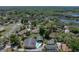 Aerial perspective of a neighborhood home, featuring a backdrop of dense trees and a distant lake at 34477 Poinsettia Pl, Dade City, FL 33523