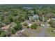 Expansive aerial view of a home with a pool, surrounded by lush greenery and a lake in the background at 34477 Poinsettia Pl, Dade City, FL 33523