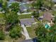Elevated view of a well-maintained home with a long drive, fence, and vibrant trees at 34477 Poinsettia Pl, Dade City, FL 33523