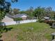 Expansive backyard featuring a white fence, fire pit, and storage shed, creating a serene outdoor space at 34477 Poinsettia Pl, Dade City, FL 33523