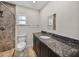 Bathroom featuring a tile walk-in shower, granite vanity and neutral colors at 34477 Poinsettia Pl, Dade City, FL 33523