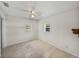 Simple bedroom features tile flooring, neutral walls, ceiling fan and natural light at 34477 Poinsettia Pl, Dade City, FL 33523