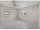 Bright bedroom featuring neutral walls, tiled floors, ceiling fan and a sunny window at 34477 Poinsettia Pl, Dade City, FL 33523