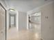 Open hallway leading to rooms featuring tile flooring, neutral walls, and traditional trim at 34477 Poinsettia Pl, Dade City, FL 33523