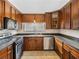 Well-equipped kitchen featuring dark wood cabinets, stainless steel appliances, and abundant countertop space at 34477 Poinsettia Pl, Dade City, FL 33523