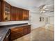 Open kitchen featuring wooden cabinets, neutral countertops, tile floors and a view into the living area at 34477 Poinsettia Pl, Dade City, FL 33523