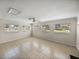 Bright living room boasts tile flooring, neutral walls, a ceiling fan, and large windows for lots of sunlight at 34477 Poinsettia Pl, Dade City, FL 33523