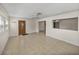 Spacious living room featuring an ornate door, neutral tile flooring, and open access to other rooms at 34477 Poinsettia Pl, Dade City, FL 33523
