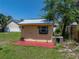 Backyard storage shed with a window and double doors, painted in an attractive pale yellow at 34477 Poinsettia Pl, Dade City, FL 33523