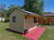 Backyard storage shed with red painted patio area, providing secure, convenient storage at 34477 Poinsettia Pl, Dade City, FL 33523