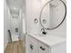 Bright bathroom featuring white cabinets, a black faucet and a large round mirror at 3455 17Th S Ave, St Petersburg, FL 33711