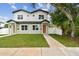 Charming two-story home with green grass, walkway and tidy landscaping on a sunny day at 3455 17Th S Ave, St Petersburg, FL 33711