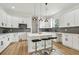 Well-lit kitchen featuring white cabinets, a large island with seating, and stainless steel appliances at 3455 17Th S Ave, St Petersburg, FL 33711