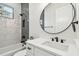 Bright bathroom featuring modern fixtures, a round mirror, and decorative accent wall tile at 3457 17Th S Ave, St Petersburg, FL 33711