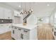 Spacious kitchen featuring a quartz island, stainless steel appliances, and staircase providing a functional and stylish layout at 3457 17Th S Ave, St Petersburg, FL 33711