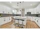 Gourmet kitchen with island, stainless appliances, white cabinets, gray tile backsplash, and stylish pendant lighting at 3457 17Th S Ave, St Petersburg, FL 33711