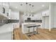 Stylish kitchen with white cabinets, center island, pendant lighting, stainless steel appliances, and wood-look flooring at 3457 17Th S Ave, St Petersburg, FL 33711
