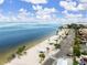 Aerial view of a beautiful community beach with palm trees, parking, and turquoise water at 3506 Seaway Dr, New Port Richey, FL 34652