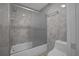 Bathroom with tub and shower combination, tiled walls, and glass door at 3506 Seaway Dr, New Port Richey, FL 34652