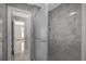 Modern bathroom featuring a glass enclosed shower with gray marble tile, open to a bedroom with tile floor at 3506 Seaway Dr, New Port Richey, FL 34652
