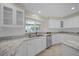 Bright kitchen features white cabinets, granite countertops, stainless steel appliances and a sunlit window at 3506 Seaway Dr, New Port Richey, FL 34652