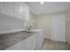 Laundry room featuring white cabinets, granite countertop, and a white washer and dryer at 3506 Seaway Dr, New Port Richey, FL 34652