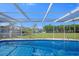 Inviting screened pool with stunning water view and lush landscaping at 3506 Seaway Dr, New Port Richey, FL 34652