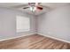 Bedroom features neutral walls, wood floors, ceiling fan, and a window with blinds at 3647 Lake St George Dr, Palm Harbor, FL 34684