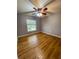 Bedroom featuring hardwood floors, a ceiling fan, and a bright window at 3647 Lake St George Dr, Palm Harbor, FL 34684