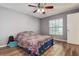 Bedroom features wood flooring, ceiling fan, and a window that provides ample natural light at 3647 Lake St George Dr, Palm Harbor, FL 34684