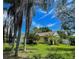 Charming single-story home with a yellow exterior, lush lawn, and mature trees in a desirable neighborhood at 3647 Lake St George Dr, Palm Harbor, FL 34684