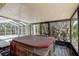 A covered hot tub enclosure, surrounded by screened windows and natural landscaping at 3647 Lake St George Dr, Palm Harbor, FL 34684