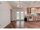 Open-concept kitchen and dining area with wood floors, a chandelier, and access to outdoor space at 3647 Lake St George Dr, Palm Harbor, FL 34684
