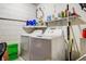 Laundry room with white brick walls, a shelf, and a washer and dryer at 3647 Lake St George Dr, Palm Harbor, FL 34684